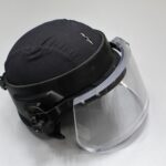 Tumma kypärä, jossa on kirkas paksu visiiri.