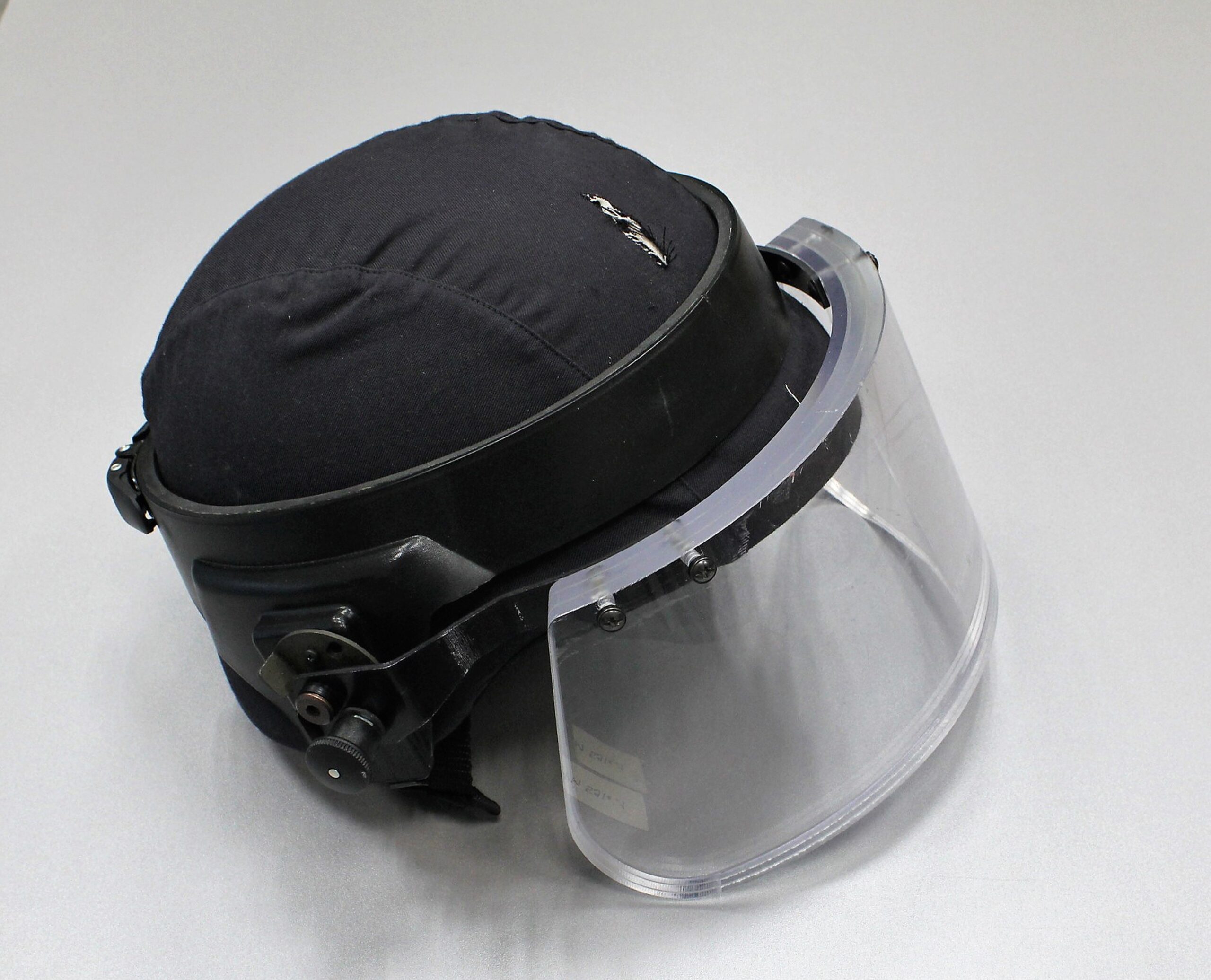 Tumma kypärä, jossa on kirkas paksu visiiri.